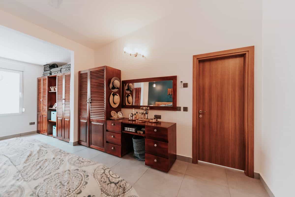 Warm, inviting bedroom with elegant wooden furniture and a mirror, illustrating wood mirror frames room by room
