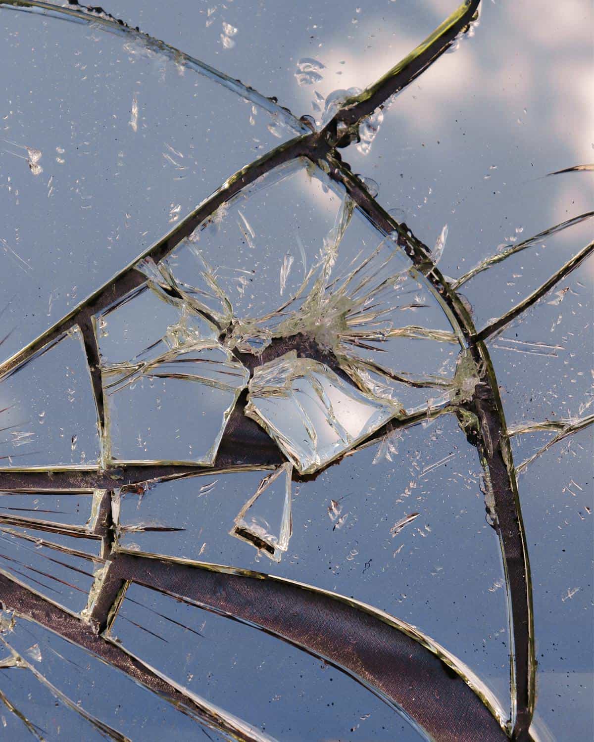 Abstract close photography of fractured mirror reflecting pale sky mosaic pattern