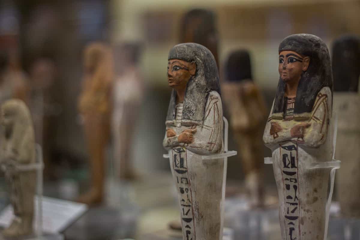 Egyptian artifacts at the Turin museum evoking the sacred objects of Hathor worship and mirror ritual in ancient Egypt Ancient Egyptian figurines on display at the Turin museum representing the artifacts and religious objects connected to Hathor and mirror ritual