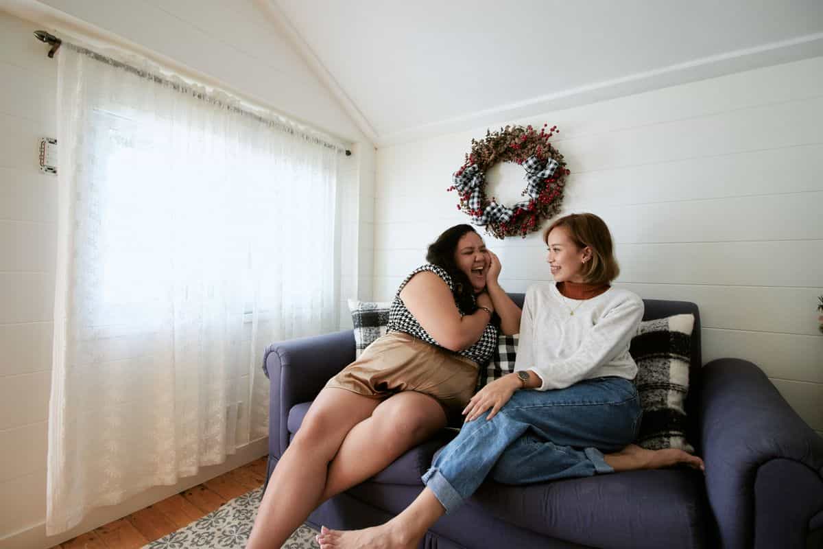 Two people talking on a sofa in a bright, cozy living room, illustrating feng shui conversation seating