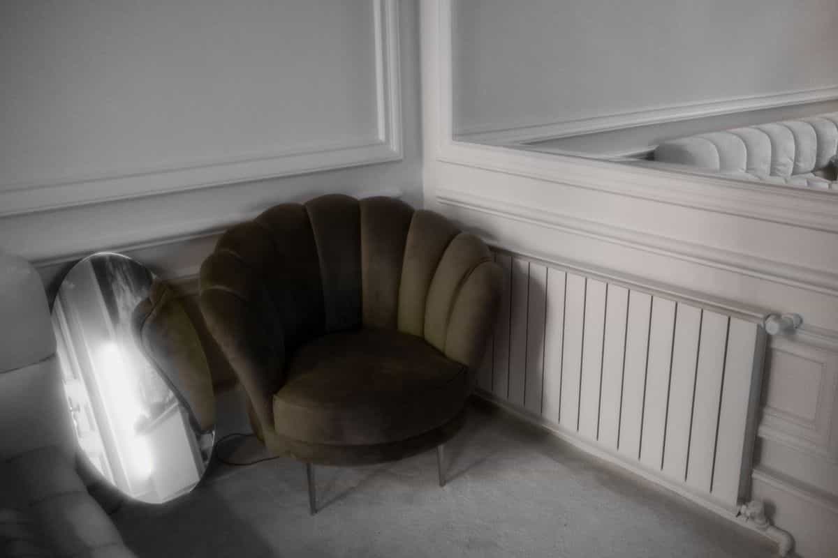 Stylish room corner with a large decorative floor mirror reflecting the decor, illustrating a leaning floor mirror