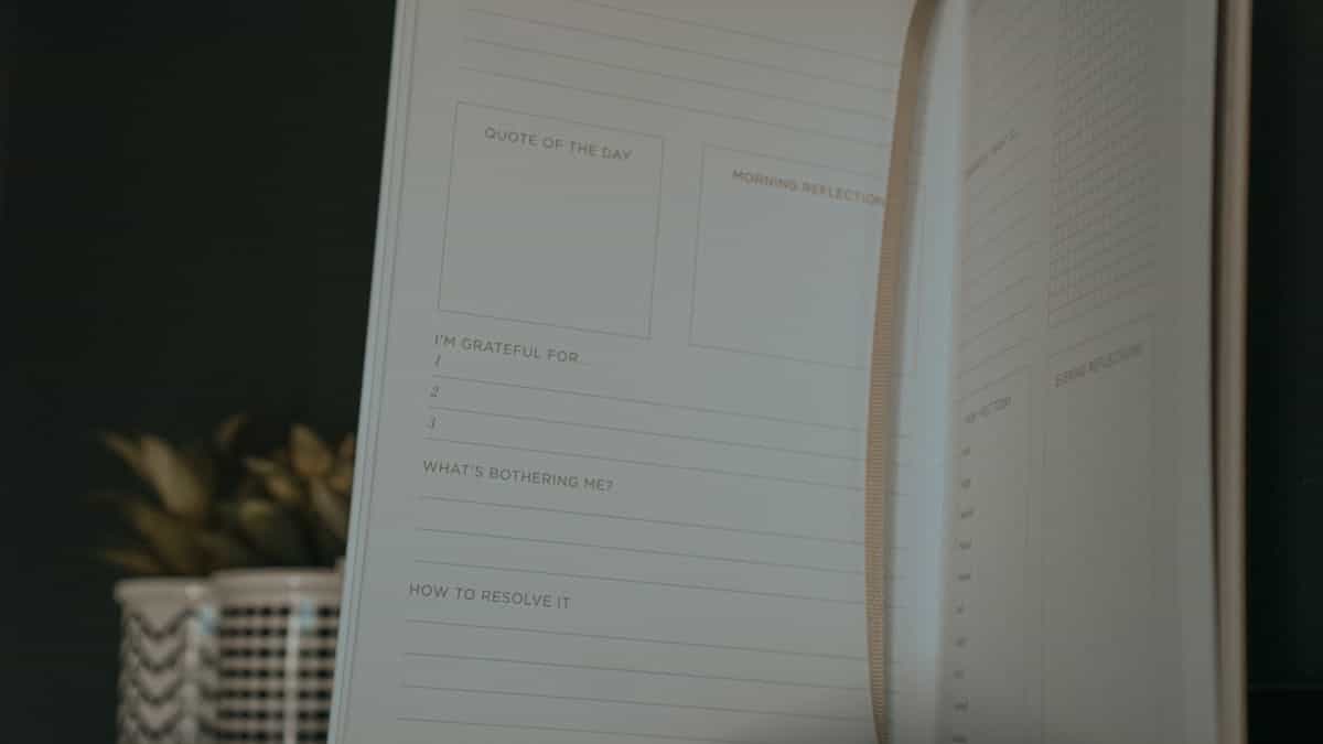 An open journal with sections for reflection, gratitude, and personal growth laid out on a clean surface ready for writing