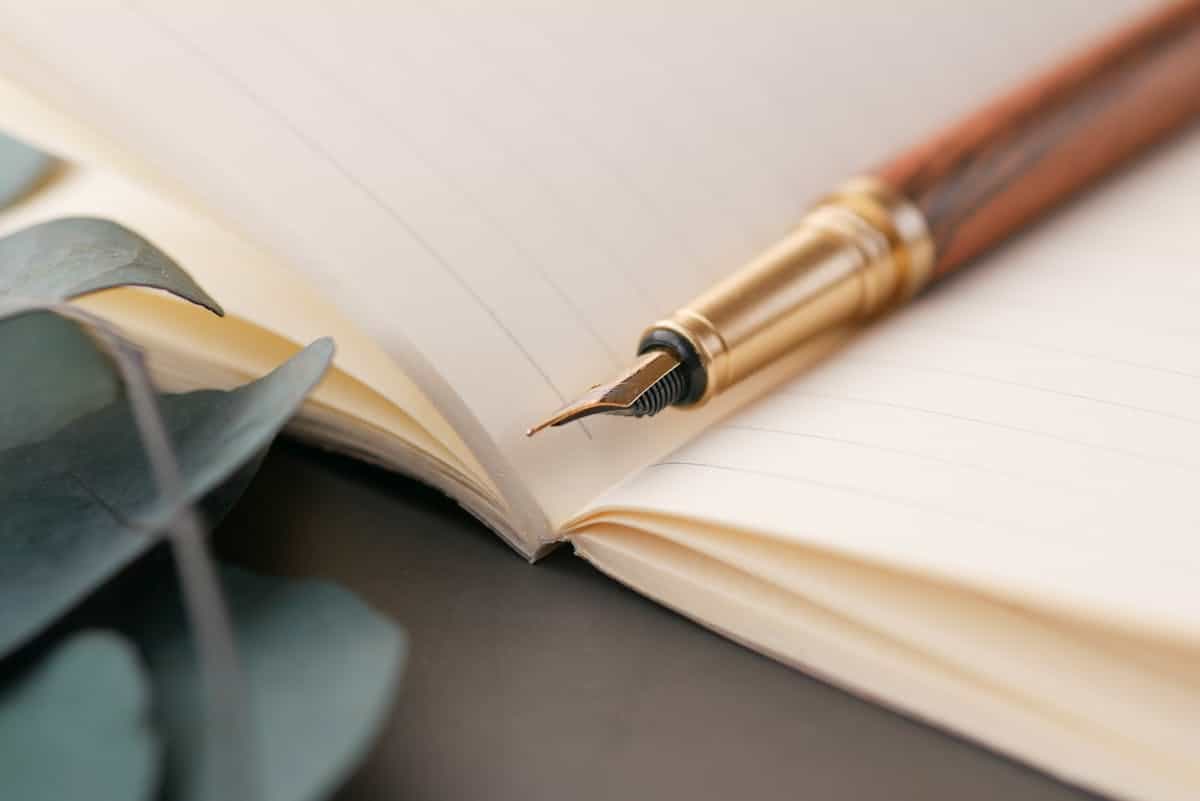 Luxury fountain pen on lined notebook for dream journaling Fountain pen resting on a lined open notebook for journaling mirror dreams and emotional processing after sleep