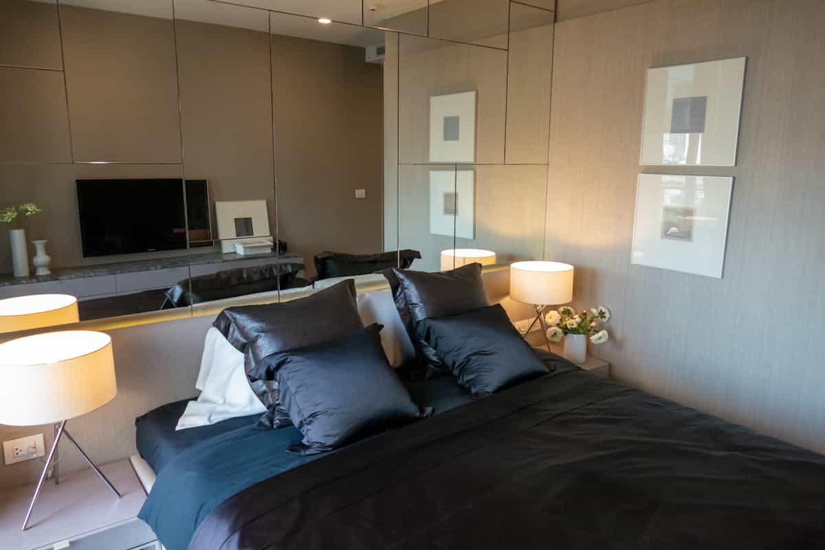 Modern bedroom with sleek decor illustrating black mirror decor in a bedroom Elegant modern bedroom with sleek design elements, illustrating black mirror decor in a bedroom