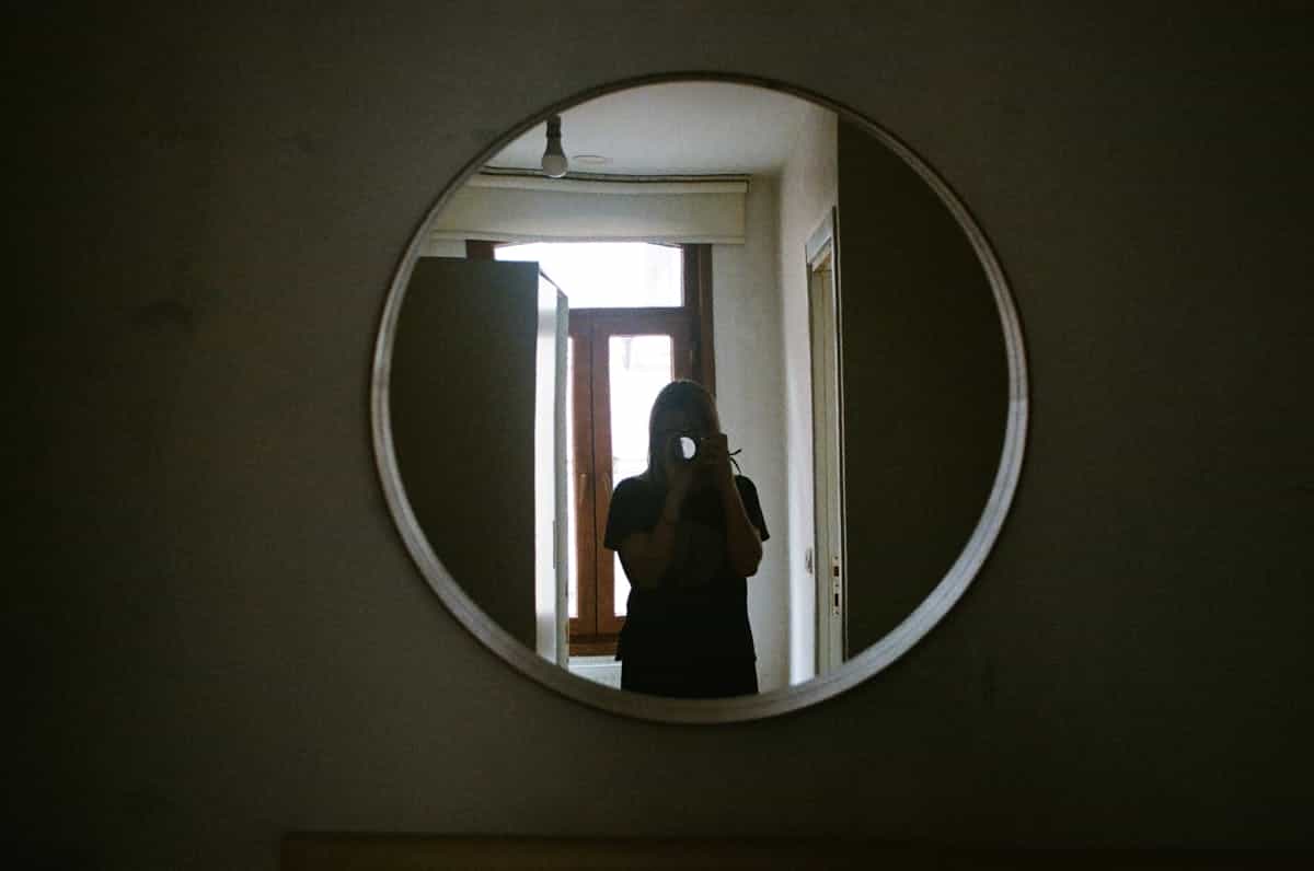 Creative circular mirror selfie framing interior hallway doubling viewer perspective like folklore portal motifs