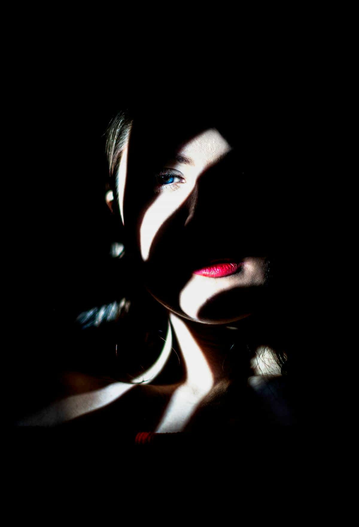 Soft portrait mood evoking transition and the blank mirror Portrait in low light suggesting the liminal self and the mirror as threshold between identities