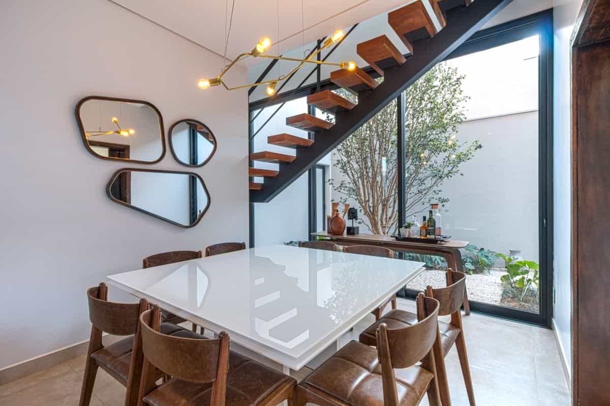 Dining area with a decorative wall mirror beside the table showing where to place mirrors for a dining room wall