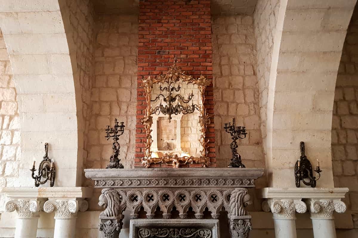 Mirror above a carved fireplace illustrating arched mirror placement over a mantel or console Carved fireplace with a mirror and candelabras in a historic interior, illustrating an arched mirror over a mantel