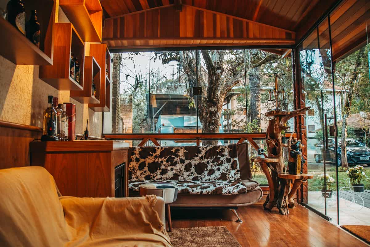 Modern living room with natural wood decor and large windows, illustrating wooden wall decor by room
