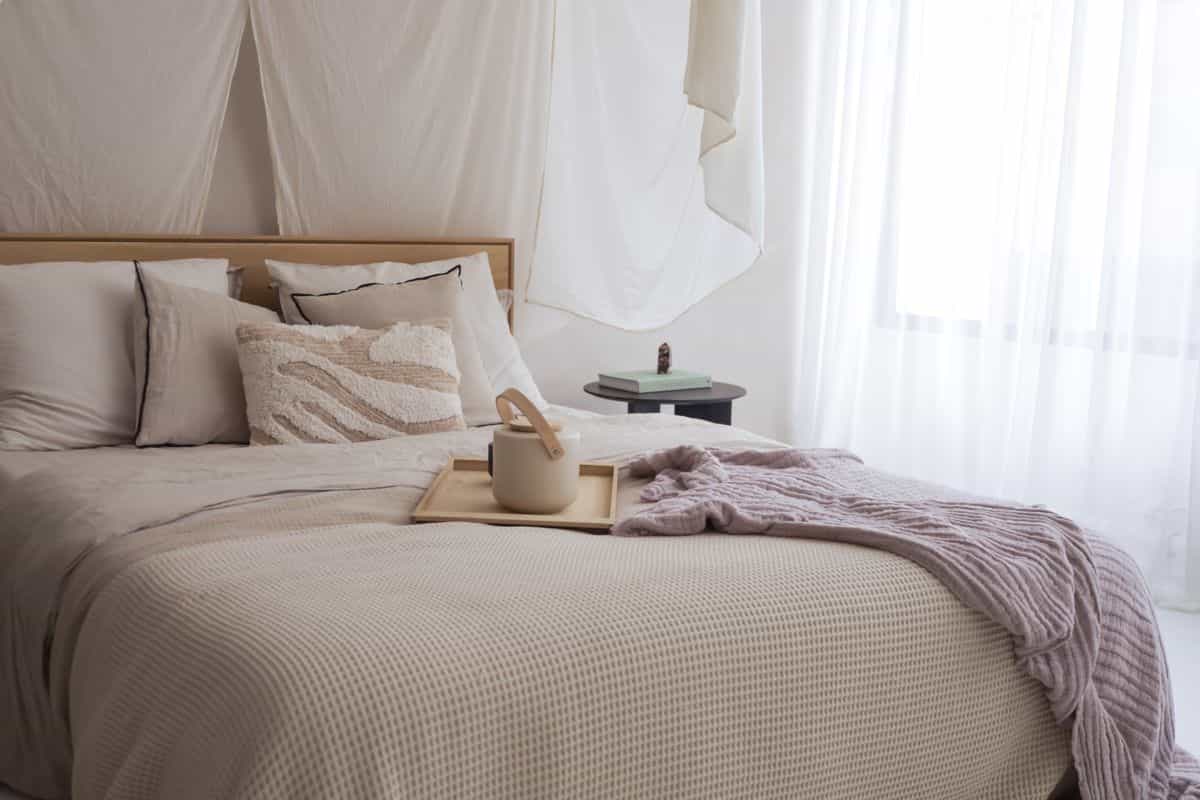Calm neutral bedroom illustrating the principles behind feng shui bedroom rules Serene bedroom with neutral textiles, soft lighting, and a cozy restful atmosphere illustrating feng shui bedroom principles
