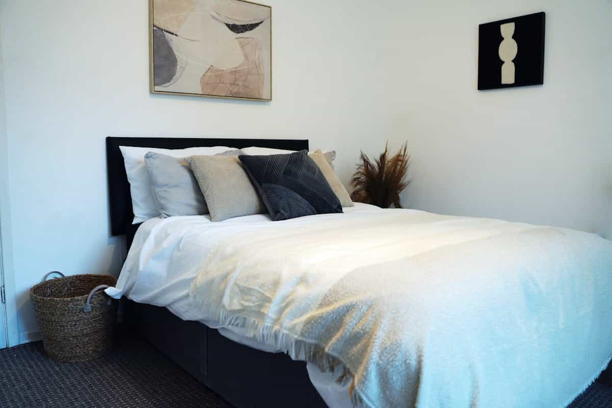 Bed arranged in the feng shui commanding position with a view of the door Calm bedroom with the bed placed to see the door, illustrating the feng shui commanding position for bed placement