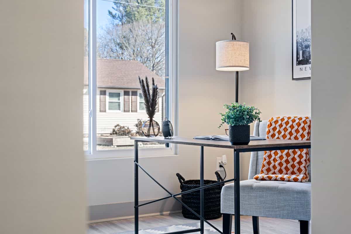 Bright home office with a minimalist desk placed directly in front of a window, illustrating feng shui desk mistakes