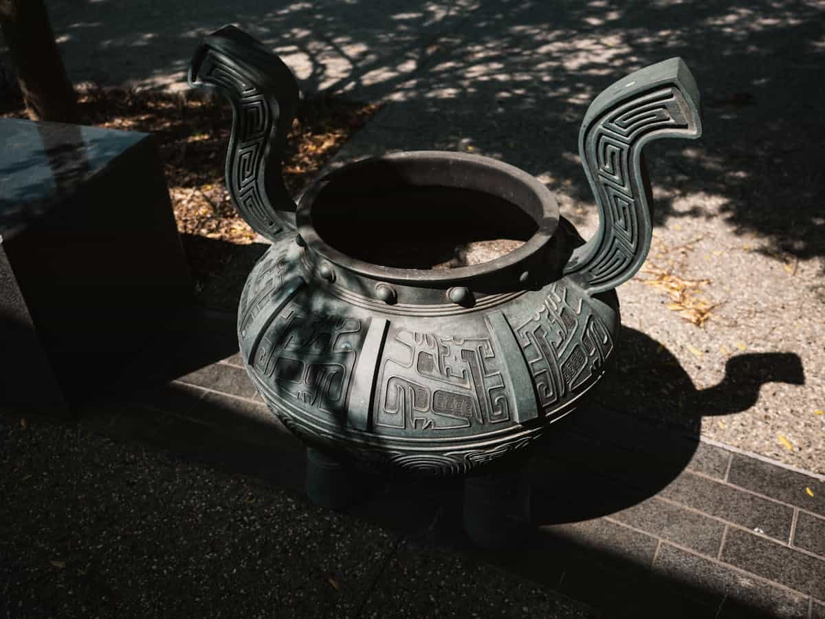 Sunlit decorative bronze vessel with intricate carvings representing the story of the women of Israel who donated bronze mirrors to build the sacred tabernacle basin in Exodus 38:8