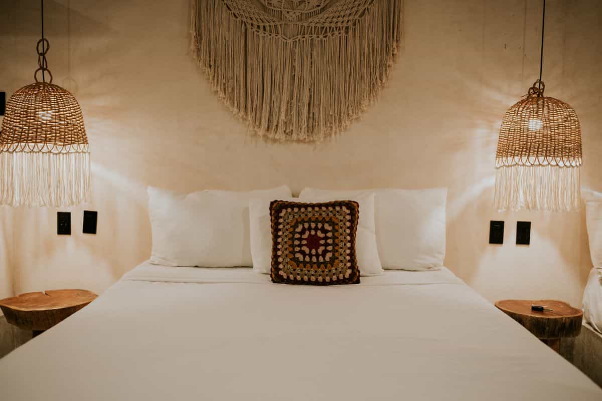 Bedroom with a macrame wall hanging illustrating woven texture for bedroom walls Bohemian bedroom with a macrame wall hanging and woven decor, illustrating texture in bedroom wall decor
