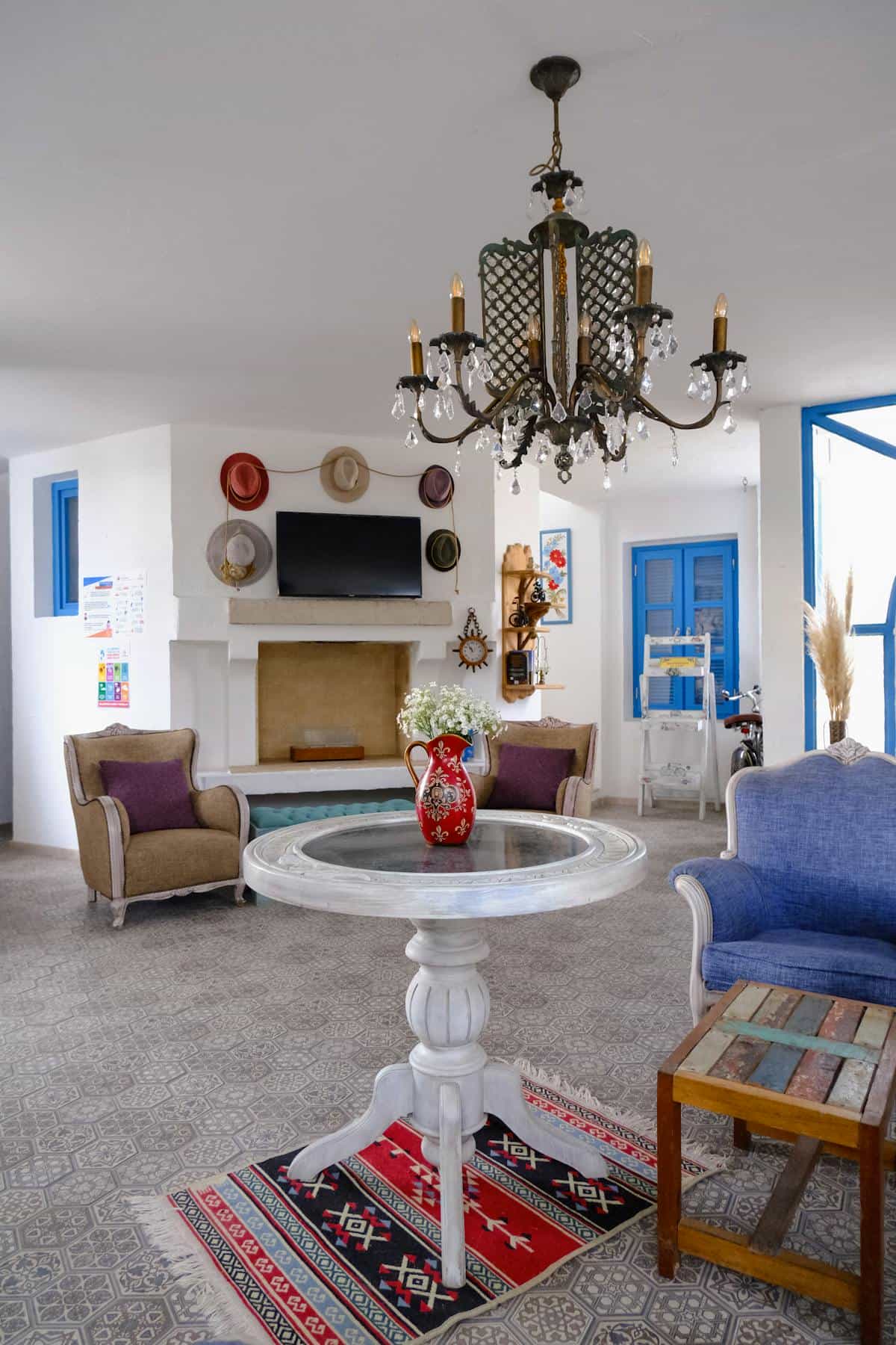 Elegant Mediterranean-influenced living room with chandelier and warm natural light