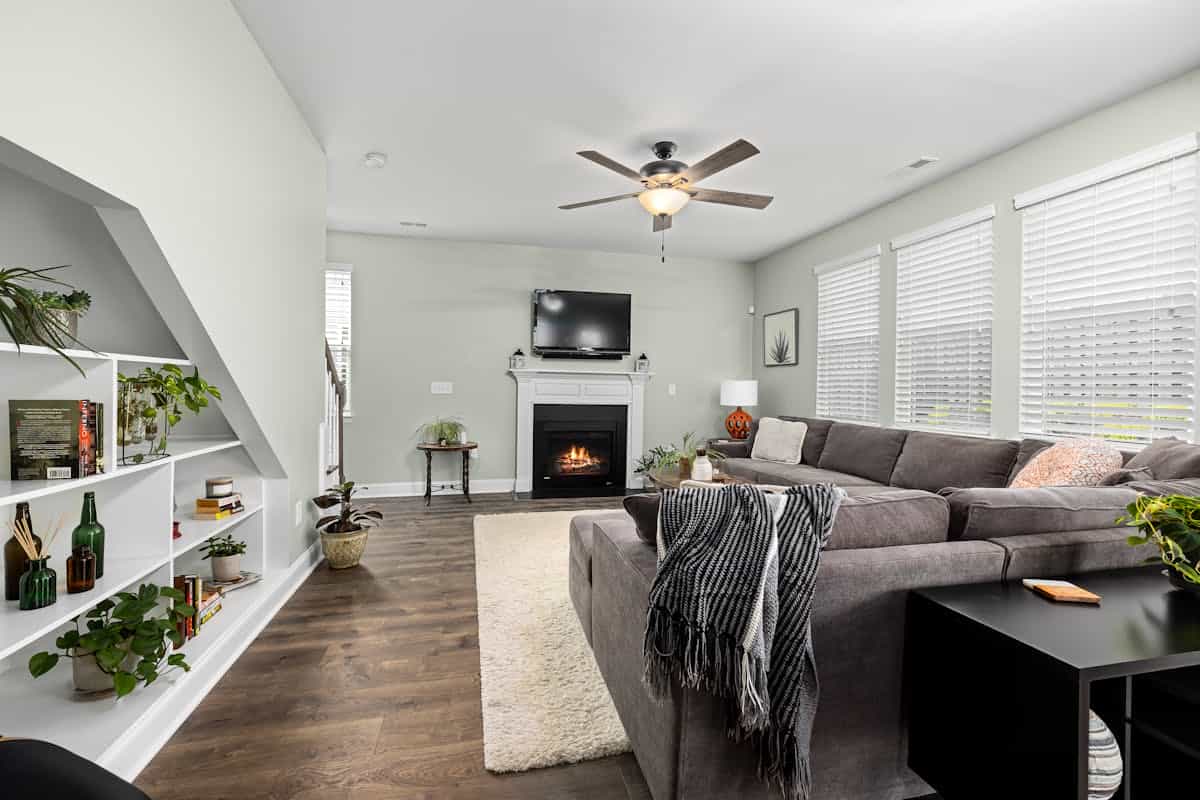 Sectional sofa forming a U-shaped seating area illustrating feng shui couch arrangement Living room with a large sectional sofa, fireplace and plants forming a U-shaped seating area, illustrating feng shui