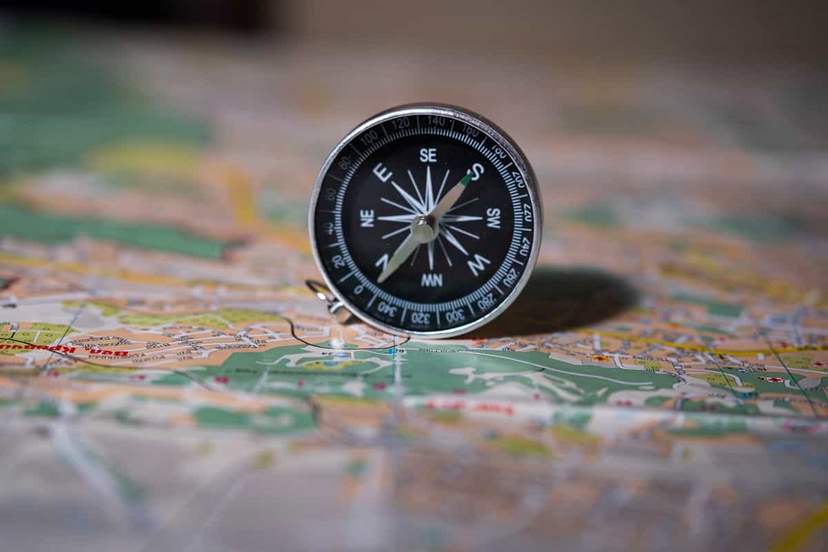 Compass on a map illustrating the general feng shui rule for sleeping direction Black compass resting on a detailed map, illustrating compass directions for feng shui sleeping direction