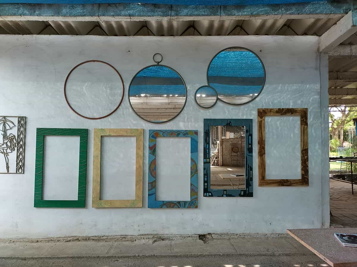 Framed and round mirrors arranged on a wall illustrating a framed-mirror grid accent wall Wall arrangement of framed and round mirrors, illustrating a framed-mirror grid accent wall