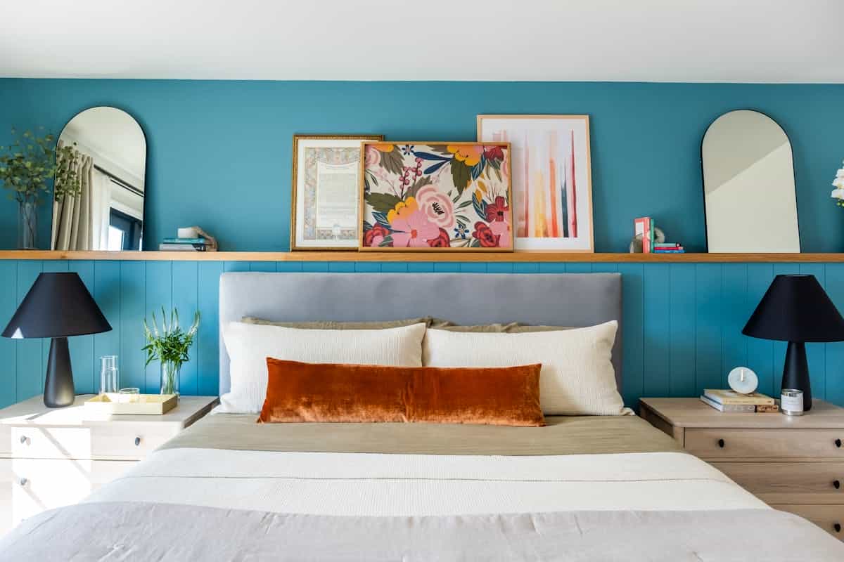 Bright bedroom with round mirrors and artwork arranged above the bed as mirror above bed styling ideas