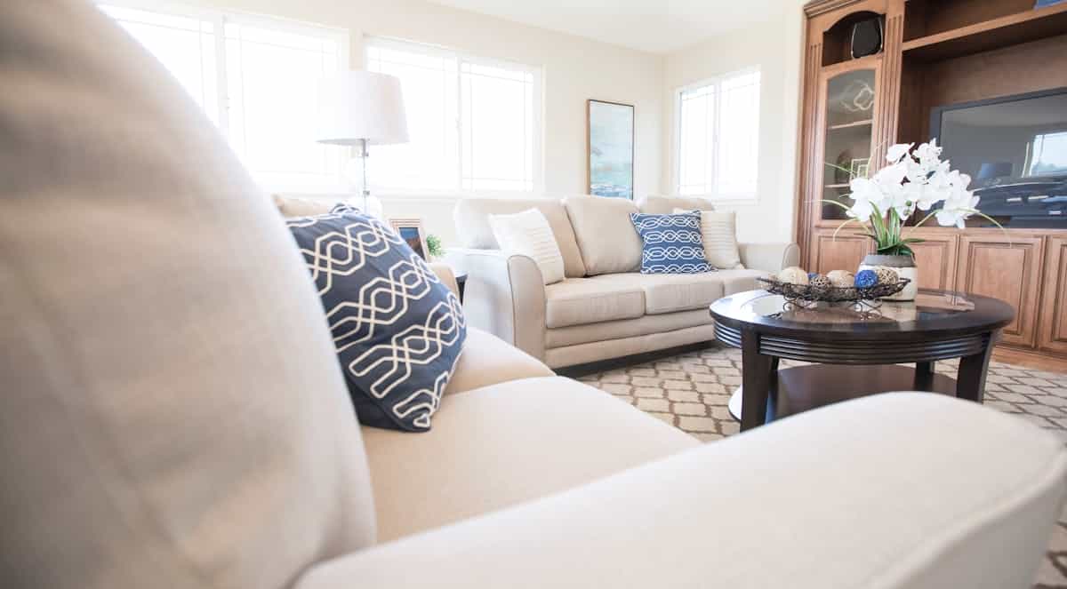 Cozy modern living room with a sofa, soft pillows and a coffee table, illustrating feng shui furniture shapes