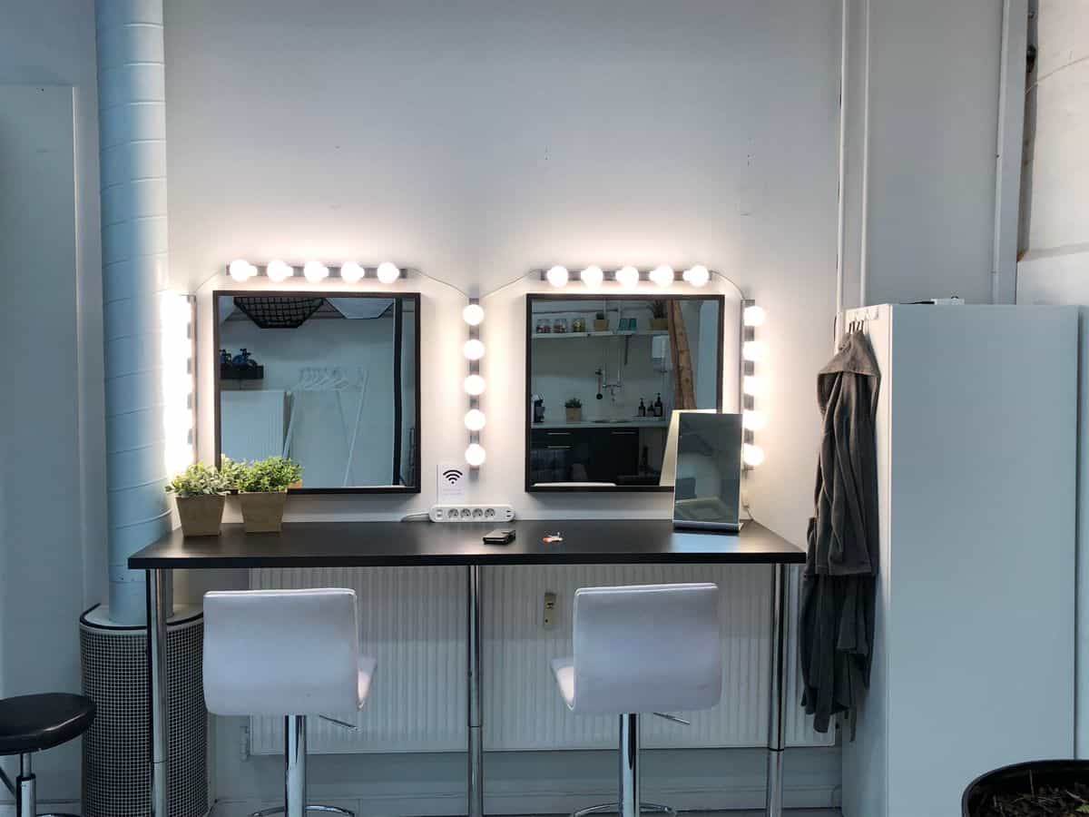 Brightly lit vanity station with a mirror and minimalist styling, illustrating a vanity mirror guide for sizes, styles, and placement.