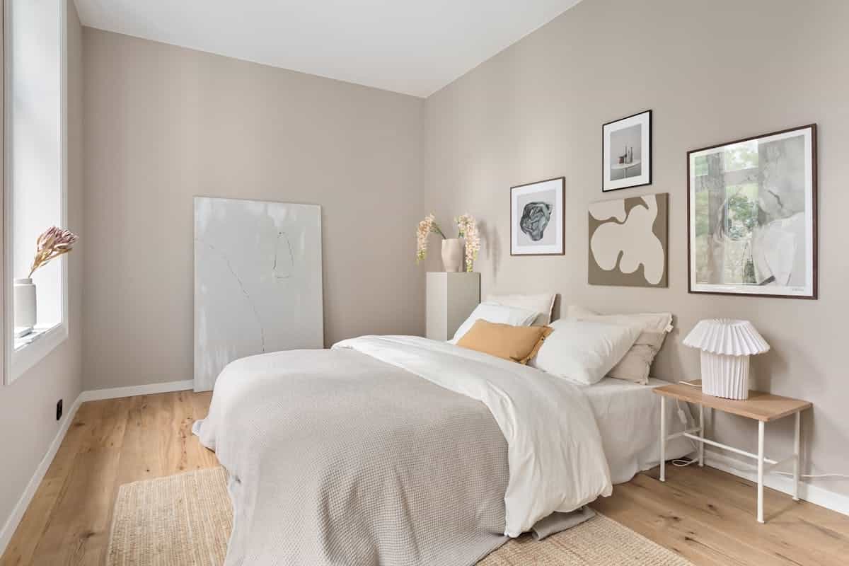 Calm neutral bedroom illustrating how feng shui bedroom colors shape the mood of a room Serene minimalist bedroom in soft neutral tones with modern art, illustrating how color shapes feng shui energy