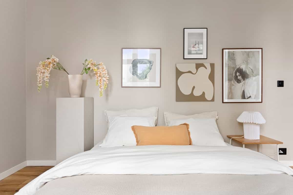 Large statement artwork in a bedroom illustrating oversized bedroom wall decor Elegant minimalist bedroom with a large piece of modern artwork, illustrating a statement piece for a bedroom wall