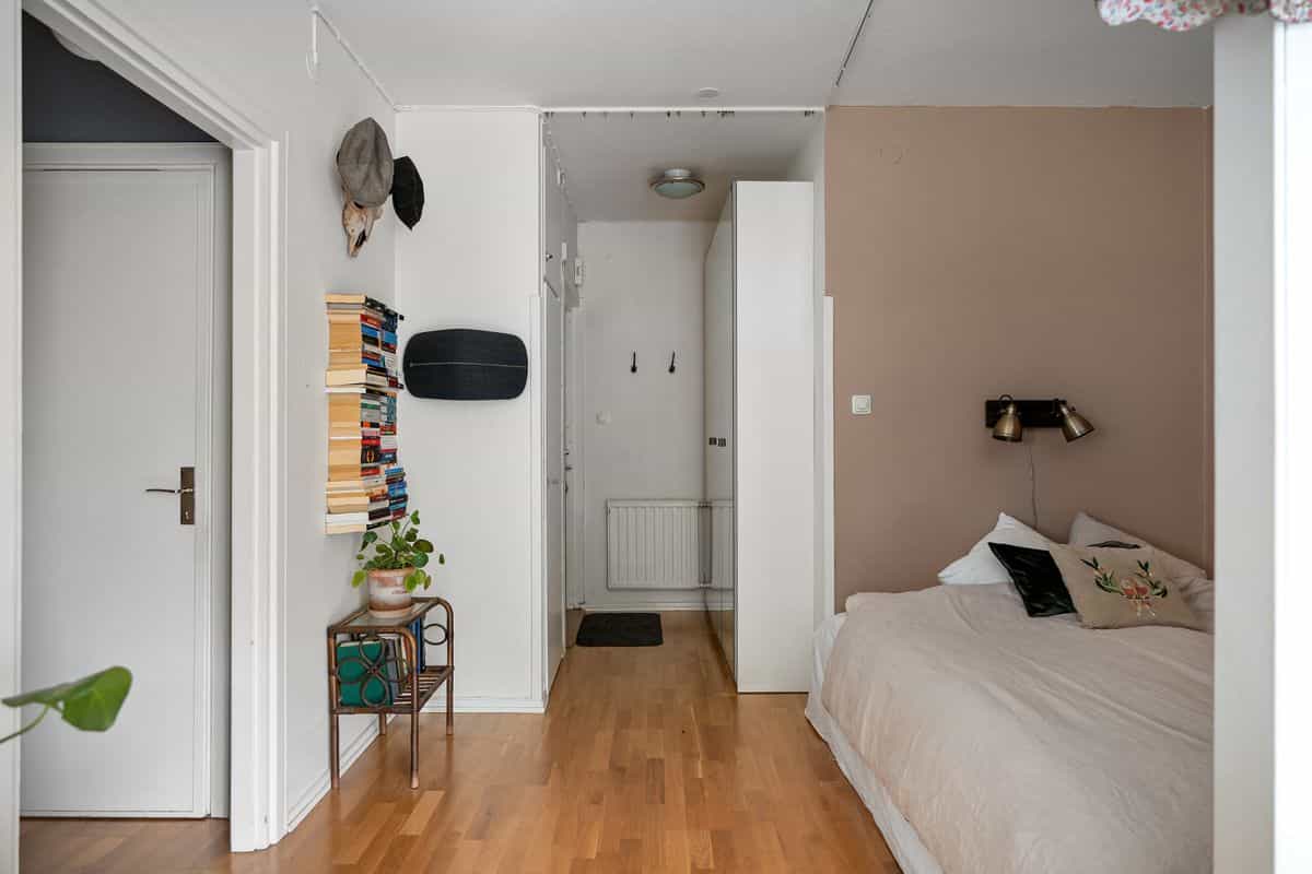 Bedroom with a styled wall shelf illustrating functional bedroom wall decor Bedroom with a wall-mounted shelf and styled decor, illustrating shelving as bedroom wall decor
