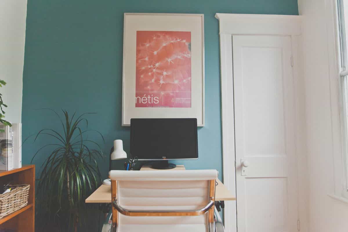 Minimalist home office with a desk and chair positioned to view the room, illustrating the feng shui command position