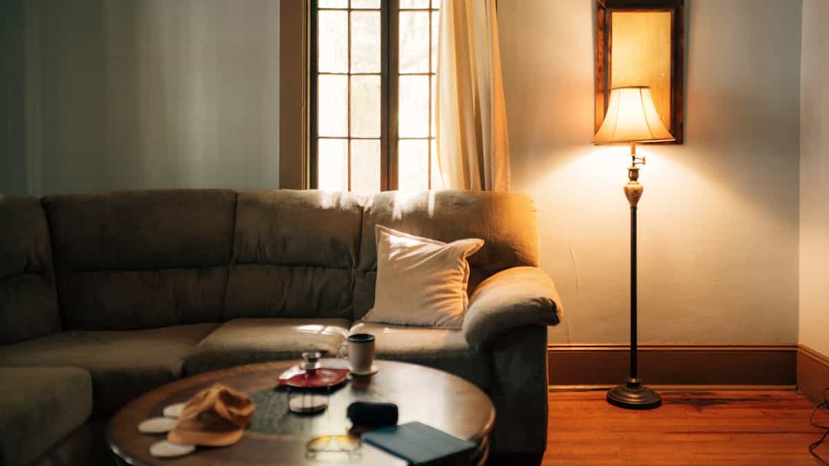 Sofa with a lamp beside it illustrating how to fix a floating sofa in feng shui Living room sofa with a floor lamp and coffee table, illustrating fixes for a floating feng shui sofa