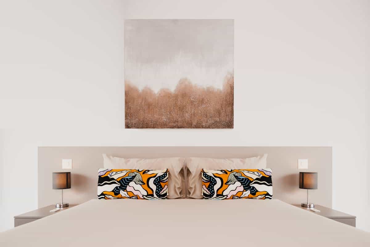 Stylish bedroom with abstract wall art and cozy decor, illustrating bedroom wall decor ideas.