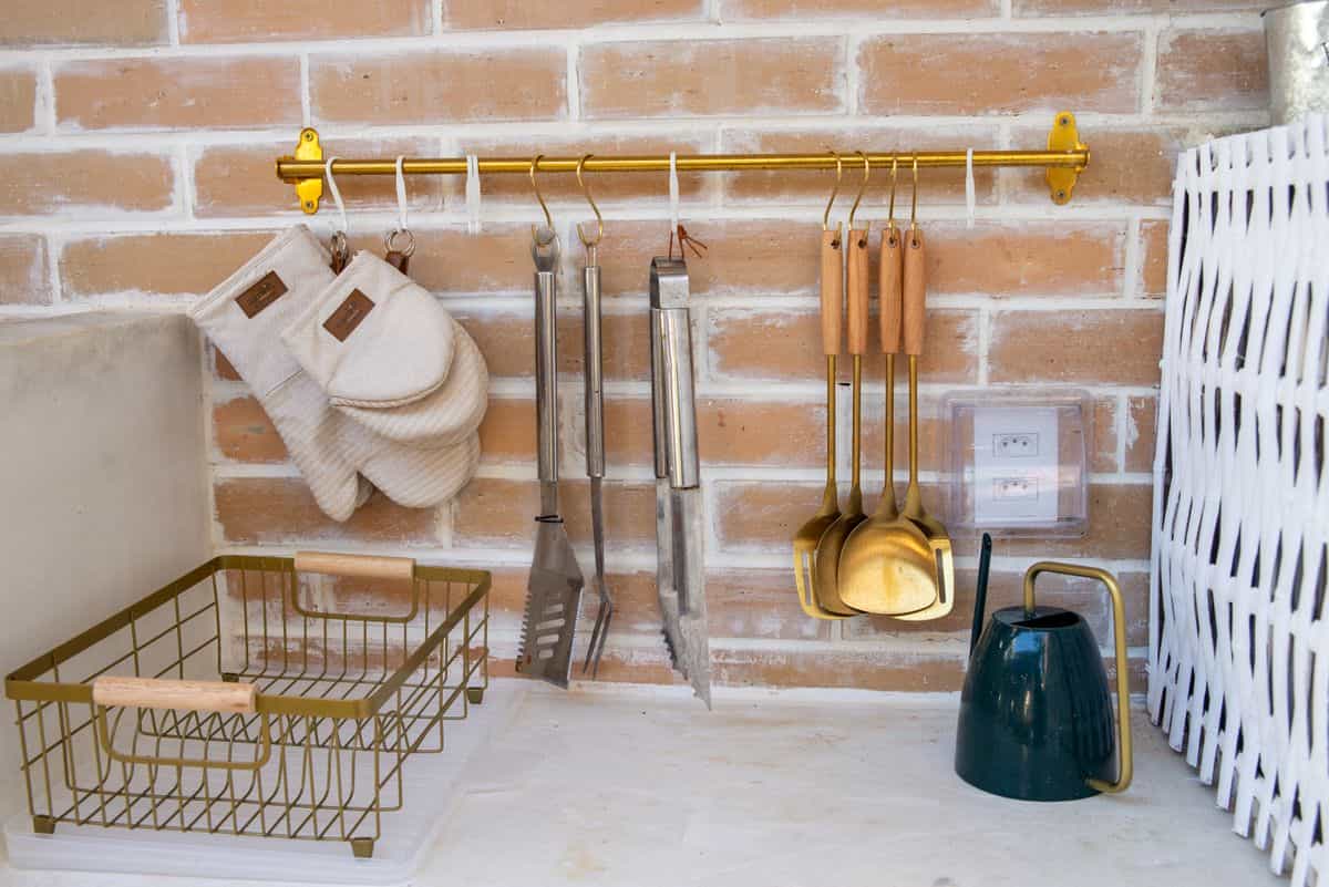 Kitchen wall decor with utensils illustrating metal kitchen signs and word art Kitchen wall with utensils and decor on a brick wall, illustrating kitchen signs and word art