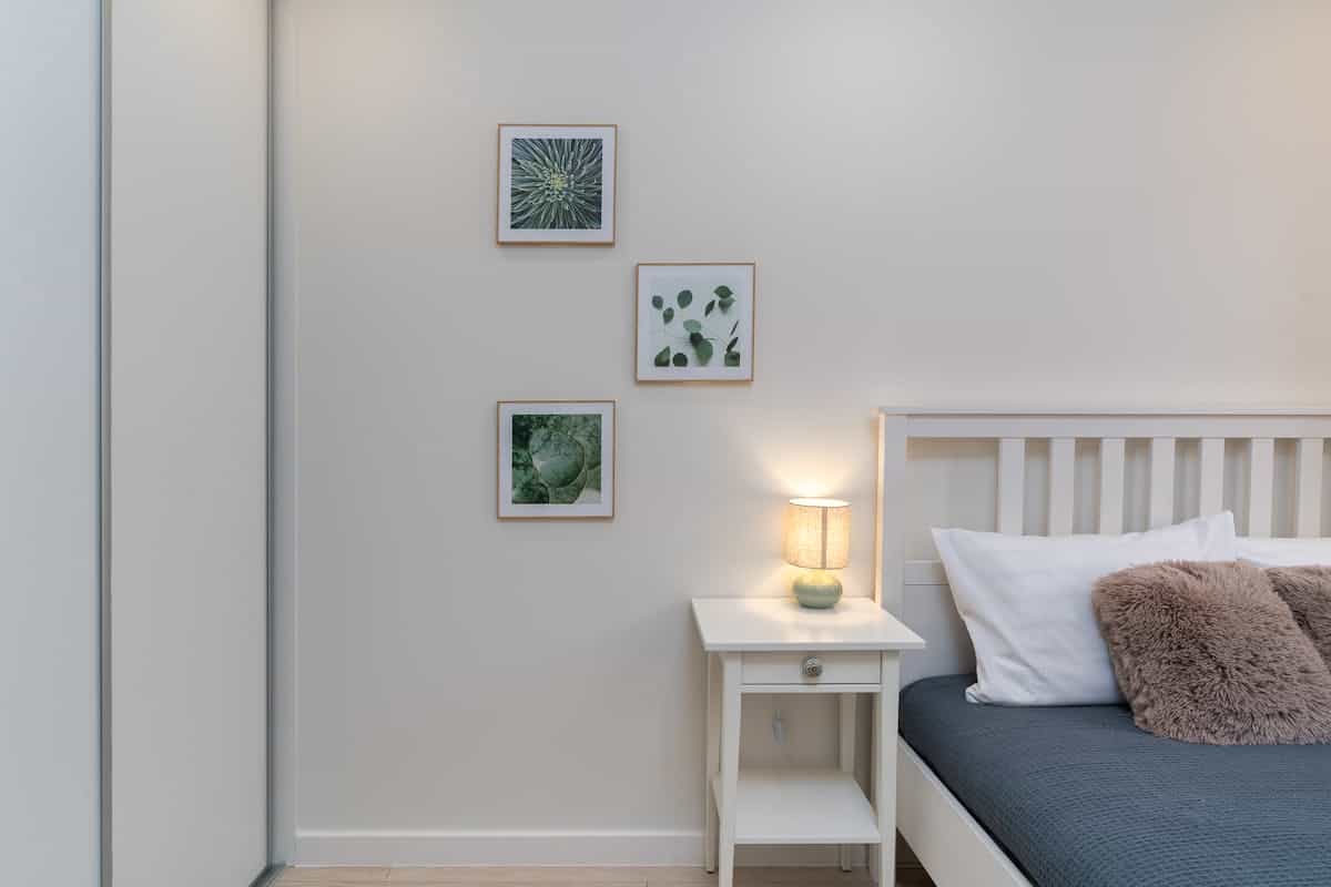 Bedroom with botanical wall art illustrating where to hang magnolia wall art Minimalist bedroom with botanical wall art and soft decor, illustrating where to hang magnolia wall art