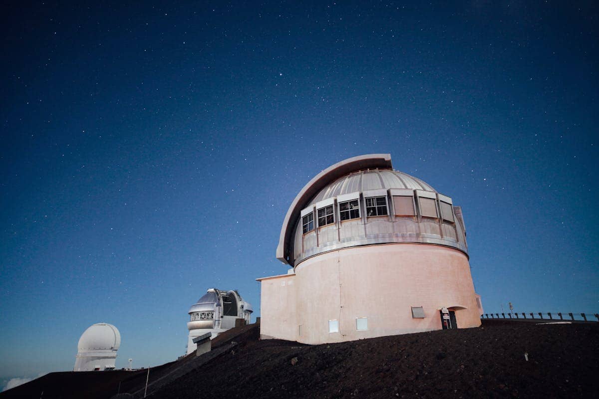 Observatory dome open under a clear starry night sky demonstrating how precision concave mirror optics in reflecting telescopes enable astronomical observation from Isaac Newtons first design in 1668 to the modern era