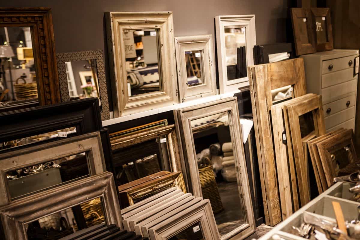 Display of vintage-style wood mirror frames in various shapes in a cozy interior, illustrating wood mirror frame shapes