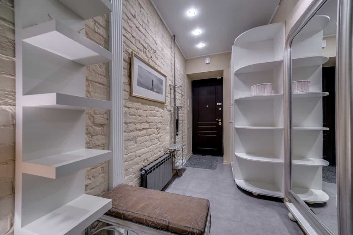 Contemporary entryway storage illustrating bench options for an entryway bench with mirror Contemporary entryway with sleek white shelving and storage, showing entryway bench storage options
