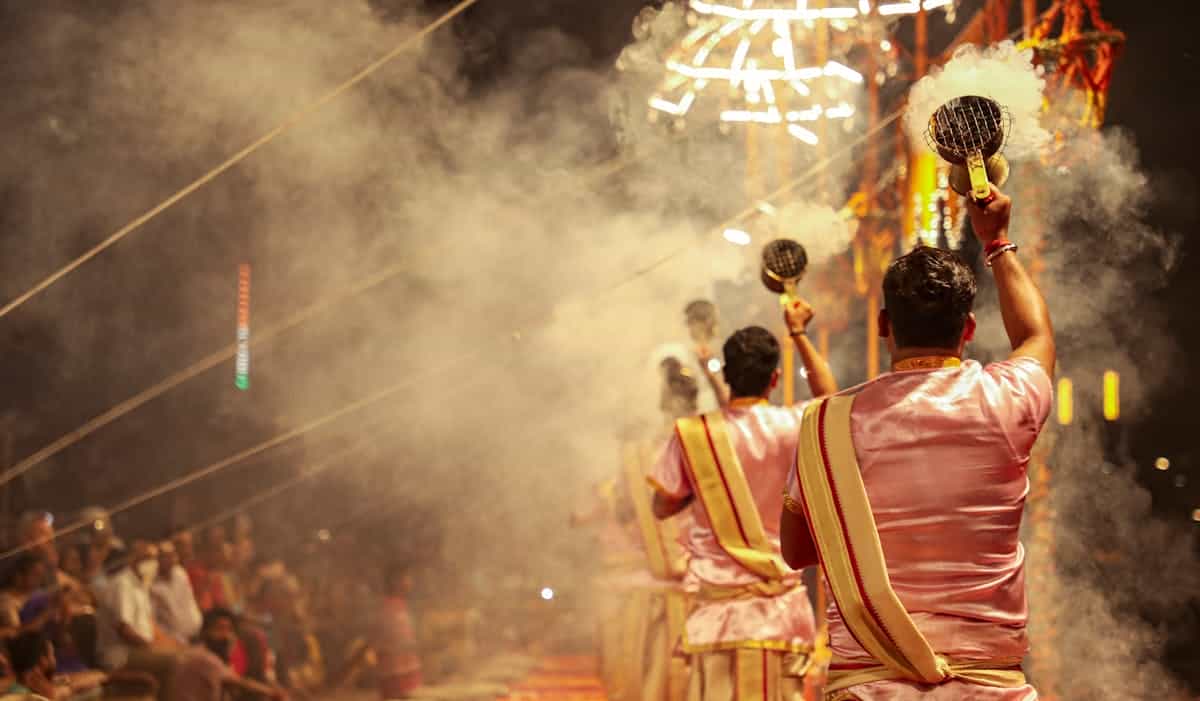 Men performing traditional rituals with incense in a vibrant cultural festival setting, representing the diverse cross-cultural interpretations of mirror symbolism and ritual significance