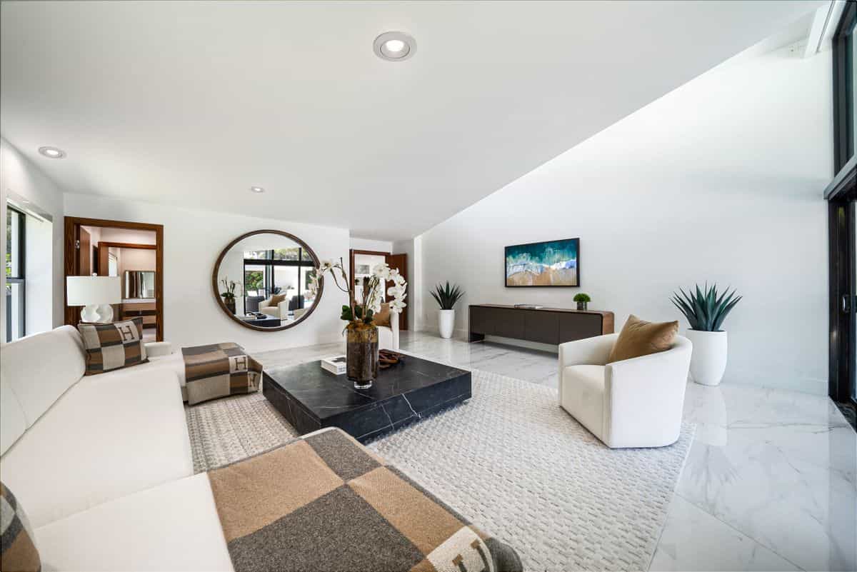Spacious modern living room with a large wall mirror and elegant furnishings, illustrating why extra large mirrors work
