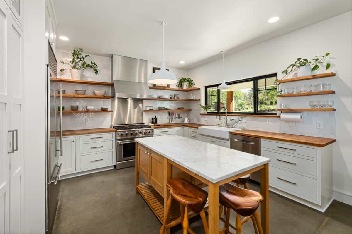 Bright kitchen with open shelving illustrating where to hang metal wall art Bright modern kitchen with open shelves and wall space, illustrating where to hang metal wall art in a kitchen