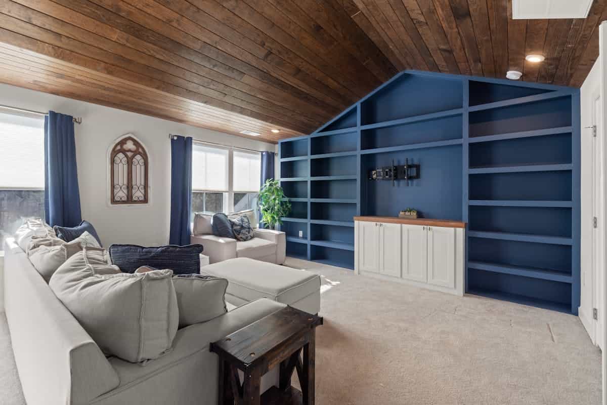 Living room with built-in shelves illustrating a functional shelving accent wall Living room with blue built-in shelves and a beige sofa, illustrating a shelving accent wall