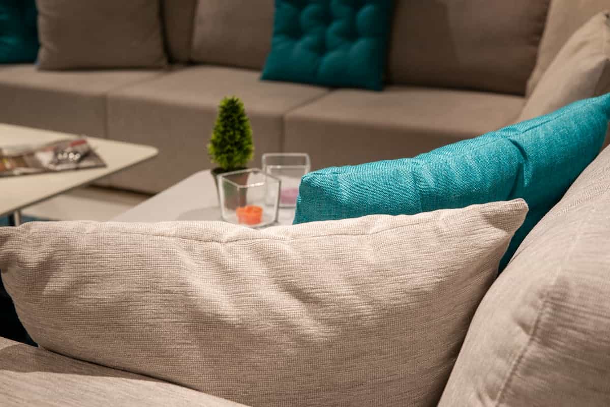 Living room with colorful accent cushions illustrating the 60/30/10 feng shui color rule Stylish living room with a neutral sofa and colorful accent pillows, illustrating the feng shui 60/30/10 color rule