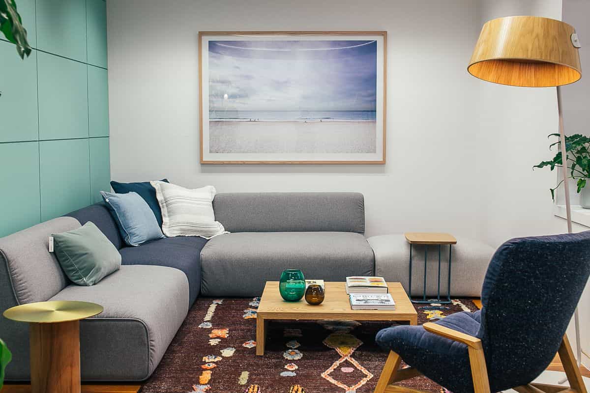 Living room with a grey sofa against a wall facing the room, illustrating the feng shui command position