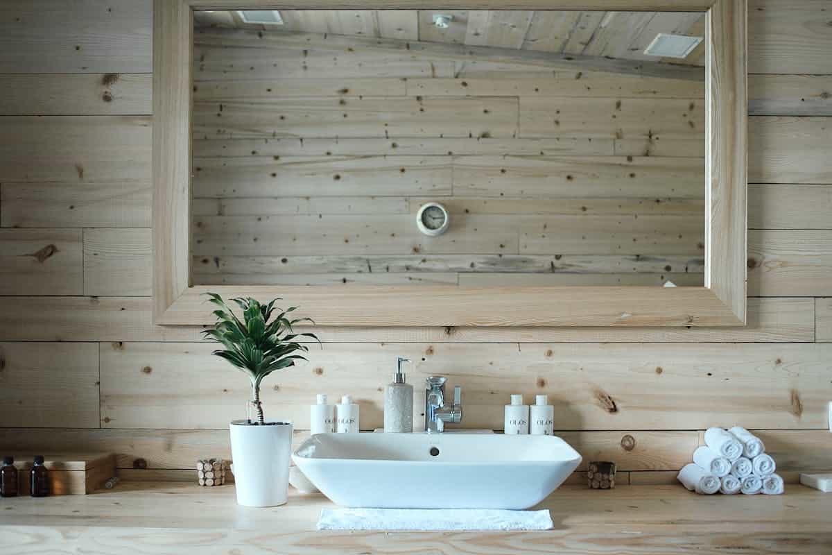 Contemporary bathroom with wooden walls and a large mirror above the sink, illustrating wood mirror frames in a bathroom