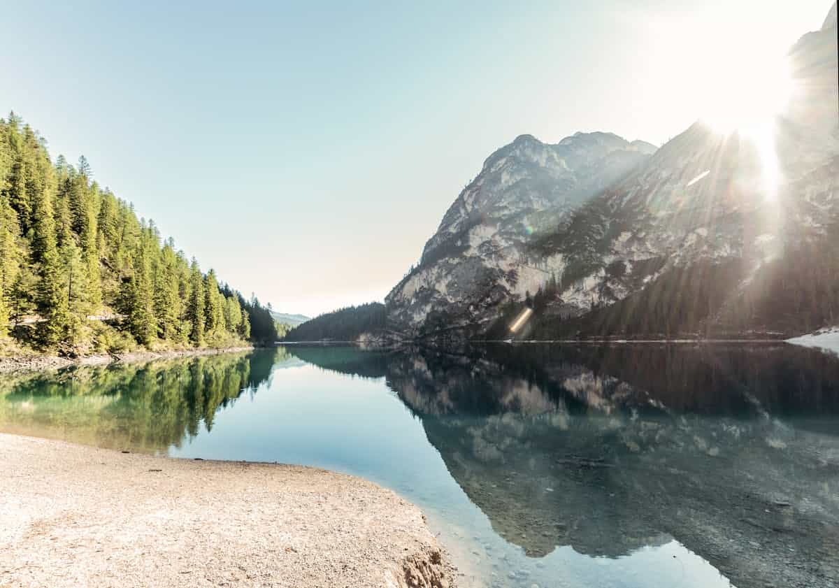 Calm lake reflecting mountains at sunrise symbolising natural mirror and contemplative clarity Serene mountain lake reflecting sunrise peaks like natural mirror for meditation and self-reflection symbolism