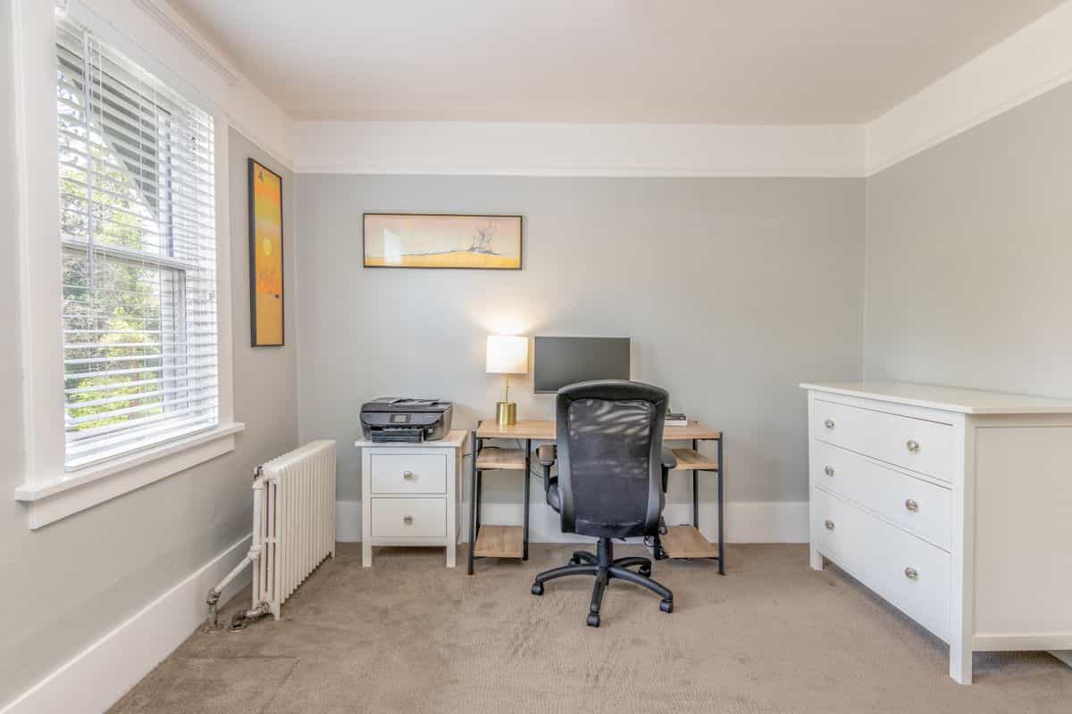 Home office desk illustrating the command position in a feng shui home office setup Bright simple home office with sleek furniture, illustrating the desk command position in a feng shui home office