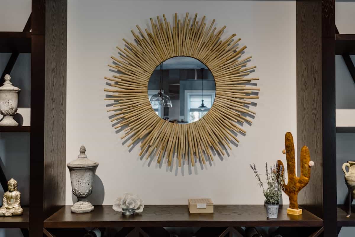 Contemporary living room with a round sunburst mirror and chic decor, illustrating round mirror decor ideas.