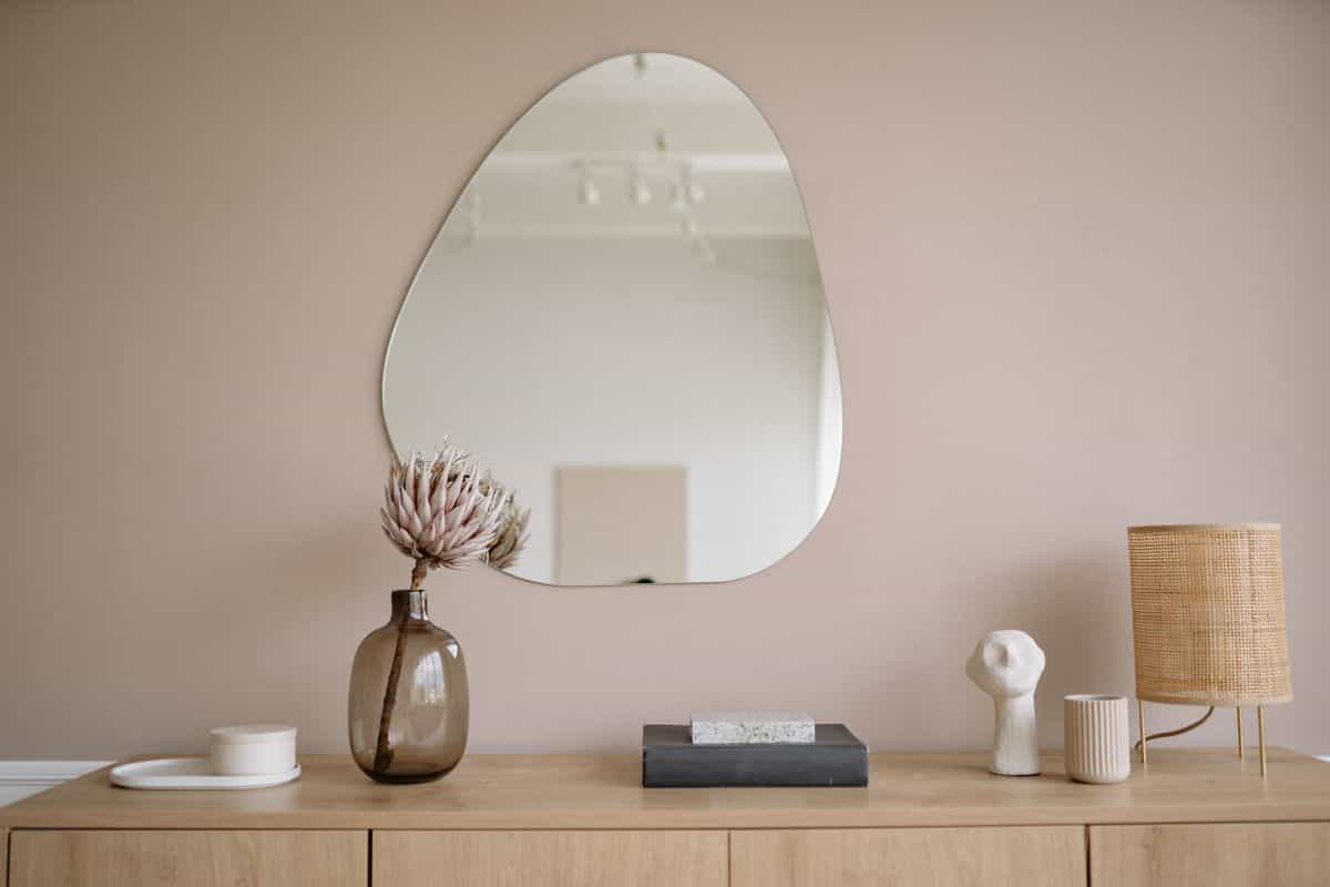 Stylish minimalist interior with a mirror, decorative vase, and lamp, illustrating where to place a full length mirror