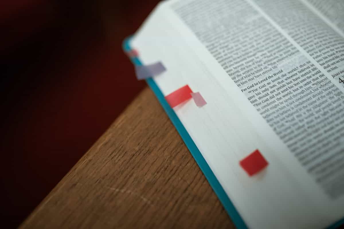 Open Bible with colorful bookmarks on a wooden desk representing the practical daily application of the mirror of Scripture for spiritual self-examination and transformation