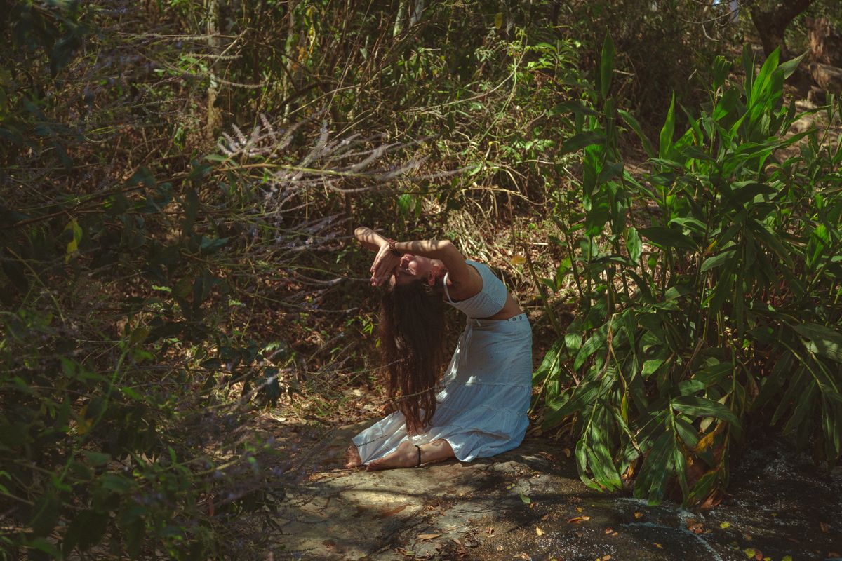 Woman performing yoga amidst vibrant green forest plants representing how to find your spirit animal