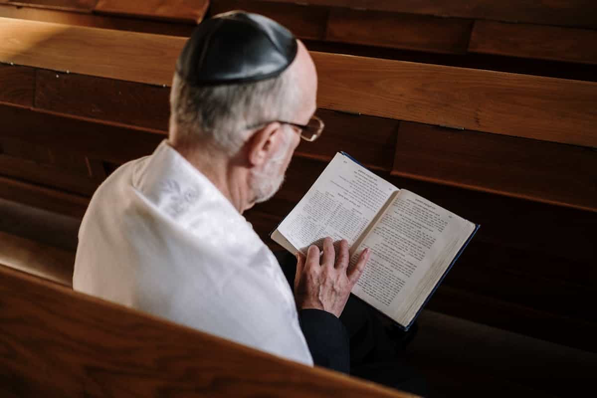 A senior man reading a sacred text in a synagogue